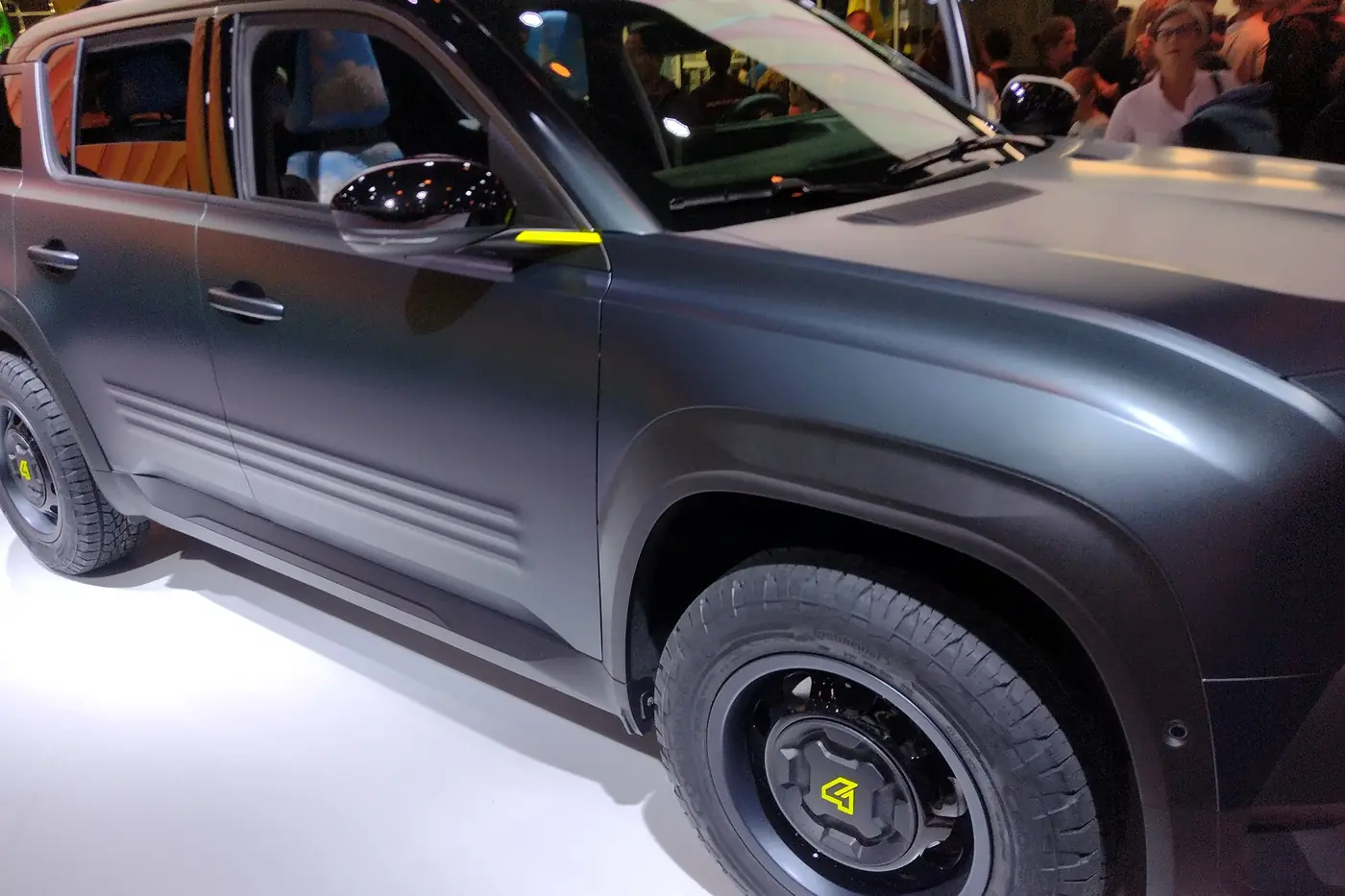Dark grey SUV in a matte finish on display at a motor show